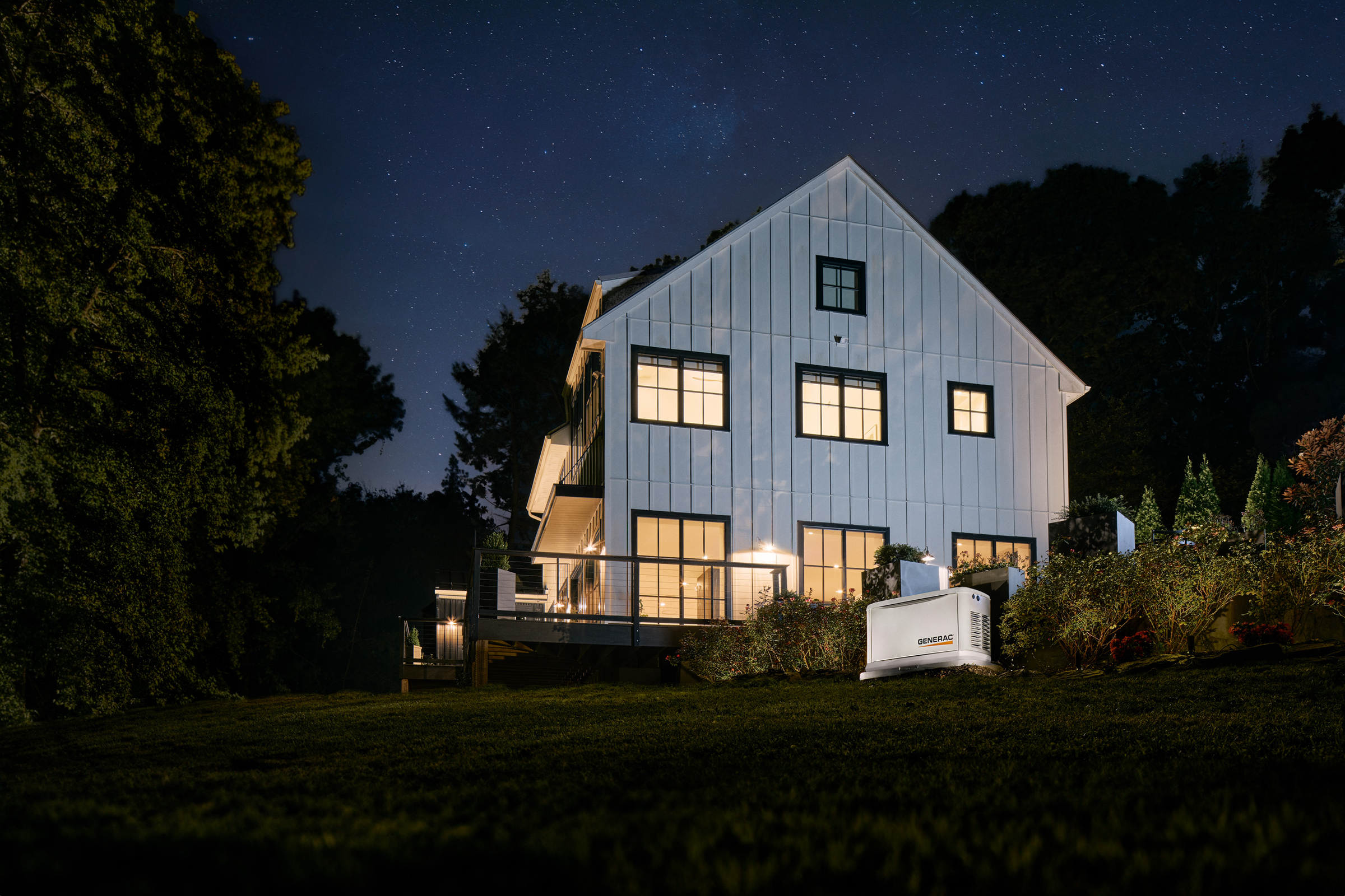 Gerador residencial iluminado em paisagismo noturno
